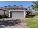 Single-story home with gray garage door and paver driveway at 5733 Semolino St, Nokomis, FL 34275