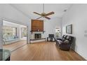 Bright living room featuring a fireplace, sliding glass doors, and hardwood floors at 652 Linden Dr, Englewood, FL 34223