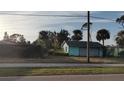 Detached teal garage with overgrown landscaping at 810 Texas St, Englewood, FL 34223