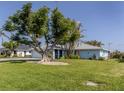 House exterior showcasing a large tree and green lawn at 1226 Pine Needle Rd, Venice, FL 34285