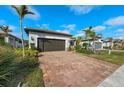 Single story house with 2-car garage, paver driveway, and tropical landscaping at 13756 Vadini St, Venice, FL 34293