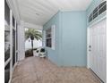 Screened-in porch with tiled floor and white wicker chair at 1634 Monarch Dr # 1634, Venice, FL 34293