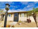 Tan house with green shutters, landscaping, and a walkway at 1953 Settlement Rd # 14, Venice, FL 34285
