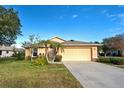 One-story house with attached garage, landscaping, and a driveway at 2134 Boxwood St, North Port, FL 34289