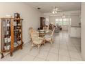 Dining area with glass table, wicker chairs, and a china cabinet at 214 Field E Ave # 1, Venice, FL 34285