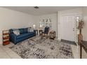 Living room with blue sofa, rocking chair, and patterned rug at 214 Field E Ave # 1, Venice, FL 34285