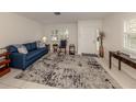 Living room with blue sofa, rocking chair, and patterned rug at 214 Field E Ave # 1, Venice, FL 34285