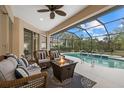 Relaxing screened patio with pool, fire pit, and wicker furniture at 2144 Calusa Lakes Blvd, Nokomis, FL 34275