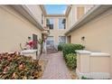 Beautiful home featuring an exterior walkway, lush plants, and many windows providing ample light at 23253 Banbury Way, Venice, FL 34293