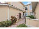 Lovely exterior view of a cream colored home with brick walkway and manicured landscaping at 23253 Banbury Way, Venice, FL 34293