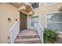 Charming front door with a welcome mat and a wreath is surrounded by neatly kept landscaping at 23253 Banbury Way, Venice, FL 34293