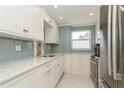Modern kitchen featuring white cabinets and stainless steel appliances at 244 Saint Augustine Ave # 107, Venice, FL 34285