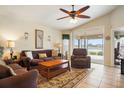 Bright living room with tiled floors, comfy seating, and view to backyard at 3789 Lakewood Blvd, North Port, FL 34287