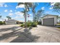 Long driveway leading to a well-maintained home with a two-car garage and a detached garage with mature landscaping at 38 Riverfront Dr, Venice, FL 34293