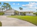 Charming single-story home featuring a two-car garage, well-manicured lawn, and a modern metal roof at 38 Riverfront Dr, Venice, FL 34293
