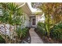 Welcoming walkway leading to the front door, surrounded by tropical plants at 450 Wexford Cir # 106, Venice, FL 34293