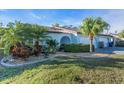 Exterior of a light blue home with a two car garage and lush landscaping at 507 Foxwood Blvd # 4, Englewood, FL 34223