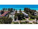 Aerial view showing beachfront community, tennis court, and pool at 5125 Gulf Of Mexico Dr # 7, Longboat Key, FL 34228