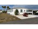 White single-wide manufactured home with green accents and mature shrubs at 788 Cervina Dr, Venice, FL 34285