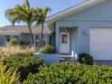 Front entrance with white door and lush landscaping at 900 Osprey St, Venice, FL 34285
