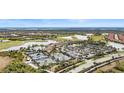 Aerial view of a luxurious community with a golf course, pool, and tennis courts at 10058 Crooked Creek Dr # 201, Venice, FL 34293