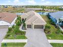 Aerial view of a two-story house with a three-car garage and landscaped yard at 10984 Trevino St, Englewood, FL 34223