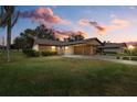Evening view of single-story home with attached garage and lush lawn at 1700 Curry Ave # 37, Nokomis, FL 34275