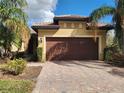 House exterior featuring a brown garage door and brick driveway at 19010 Mangieri St, Venice, FL 34293