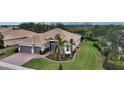 One-story house with a gray garage and palm trees in the yard at 19500 Petrino St, Venice, FL 34293