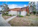 Tan and brown condo with landscaped yard and walkway at 2066 Sunset Point Rd # 91, Clearwater, FL 33765