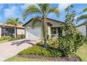 Single story house with a two-car garage and palm trees at 232 Teramo Way, Nokomis, FL 34275