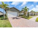 Two-story house with a two-car garage, landscaping and a brick driveway at 232 Teramo Way, Nokomis, FL 34275