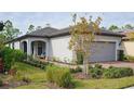 One-story house with gray garage door, landscaping, and walkway at 2751 Lavandula Ct, North Port, FL 34289