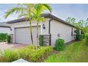 Side view of house showcasing gray garage door and stone accents at 2751 Lavandula Ct, North Port, FL 34289