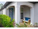Front porch with blue bench, wreath and brick flooring at 2751 Lavandula Ct, North Port, FL 34289