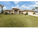 Tan house with lush lawn, attached garage, and mature landscaping at 4743 Butterfly Ln, North Port, FL 34288