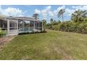 Large backyard with screened pool, patio, and lush landscaping at 4743 Butterfly Ln, North Port, FL 34288
