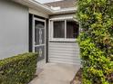 Front entrance with a screen door and well-manicured landscaping at 703 Ironwood Dr # 114, Venice, FL 34292