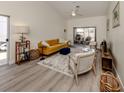 Bright living room with a mustard sofa, a neutral armchair, and hardwood floors at 703 Ironwood Dr # 114, Venice, FL 34292