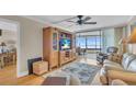 Living room with hardwood floors, built-in cabinet, and recliner at 840 The Esplanade N # 703, Venice, FL 34285
