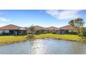 Waterfront community view showcasing multiple homes and lush landscaping at 9824 Haze Dr, Venice, FL 34292