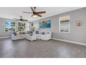 Bright living room with tile flooring, two ceiling fans, and comfy sofas at 9824 Haze Dr, Venice, FL 34292
