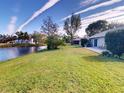 Home's back overlooks a pond, featuring a patio and grassy yard at 104 Woodingham Dr, Venice, FL 34292