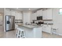 Modern kitchen with white cabinets, granite countertops, and stainless steel appliances at 11945 Lovegrass St, Venice, FL 34293