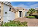Tan house with tile roof, white garage door, and nicely landscaped yard at 13240 Guyana St, Venice, FL 34293