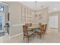 Bright dining area with glass table and six chairs, adjacent to entryway at 135 Braemar Ave, Venice, FL 34293