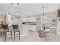 Kitchen features white cabinetry, breakfast bar, and a small dining table at 135 Braemar Ave, Venice, FL 34293