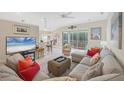 Spacious living room with sectional sofa, large TV, and sliding glass doors at 135 Braemar Ave, Venice, FL 34293