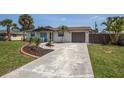 Front yard with landscaping and a paved driveway leading to the garage at 140 Columbia Rd, Venice, FL 34293