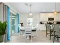 Cozy dining area featuring a white round table, pendant lighting, and sliding door access to the patio at 1920 Sunset Preserve Way, Port Charlotte, FL 33953